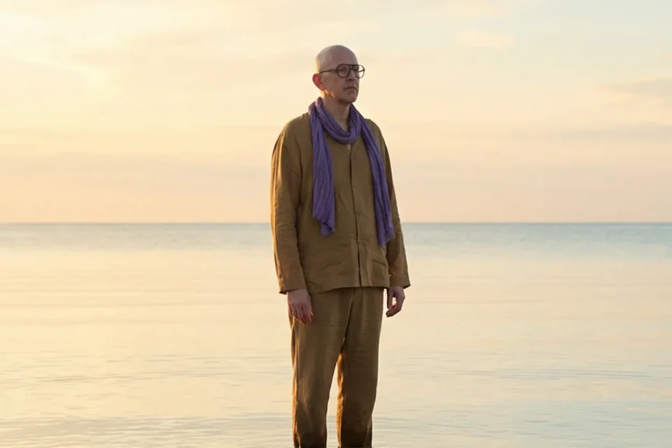 Marco Maso in piedi nell'acqua calma del mare all'alba